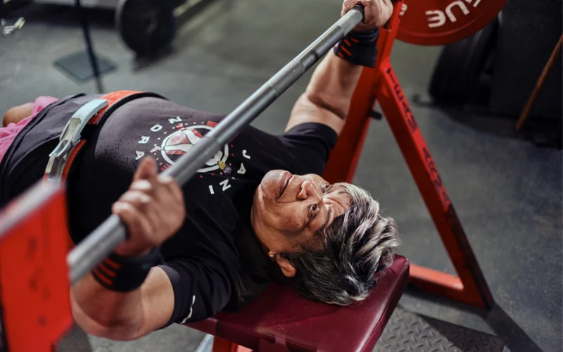 An older woman bench-pressing