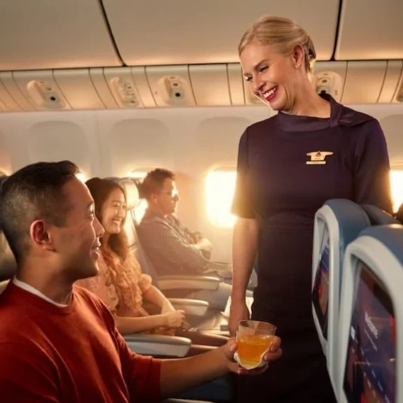 A flight attendant tends to a customer onboard a Delta flight.