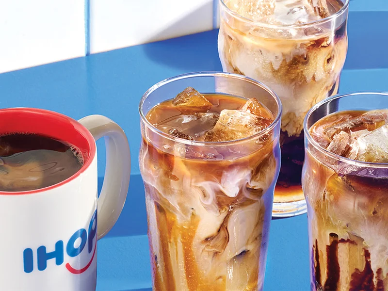 Hot coffee in an IHOP mug beside three iced coffees in glasses.