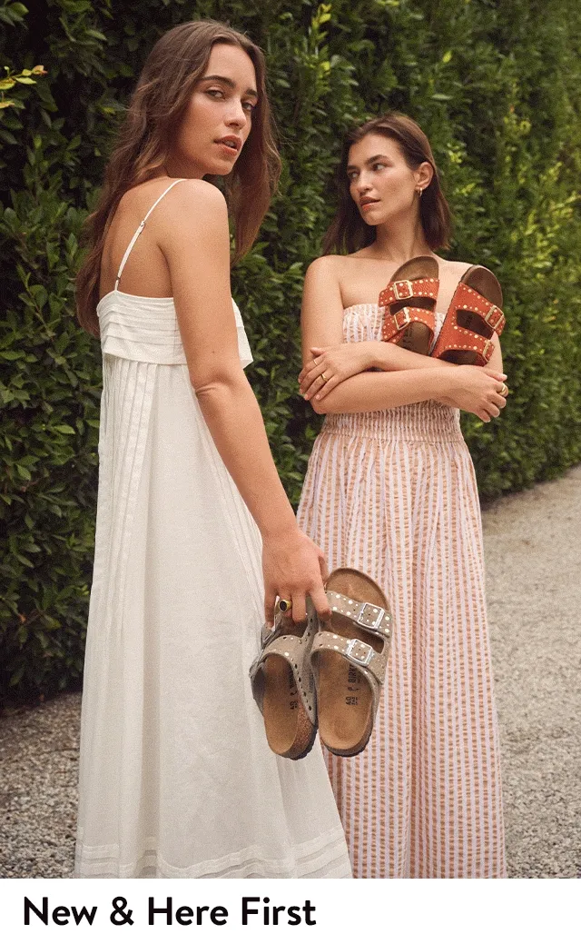 Two women holding Birkenstock sandals.