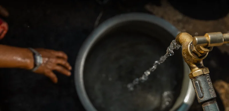 Ram fills a container with clean water from his solar-powered system.
