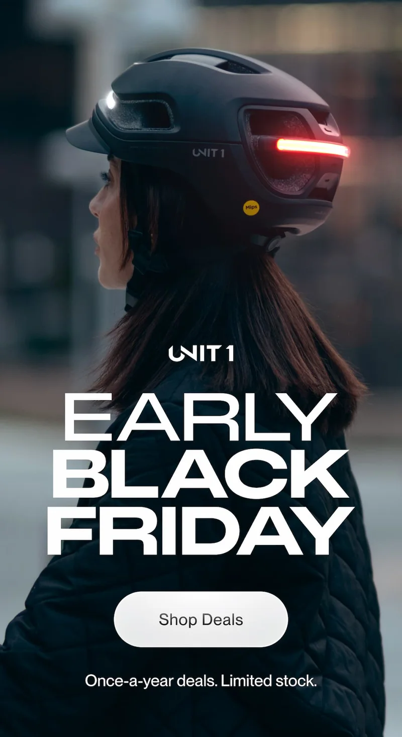 Rider wearing a UNIT 1 Smart Helmet at dusk with lights on for Early Black Friday.