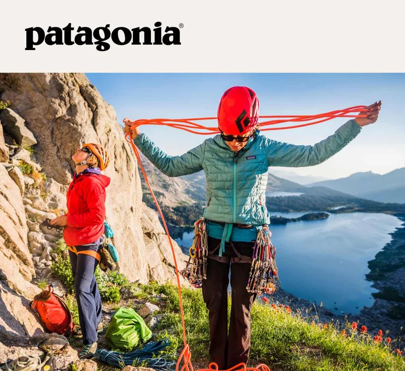 Two climbers at the base of a route overlooking an alpine lake.