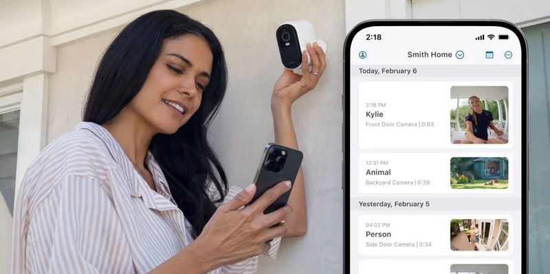 Person setting up an Arlo security camera. A phone with a simulated Arlo screen image displays an event feed in the Arlo Secure app.