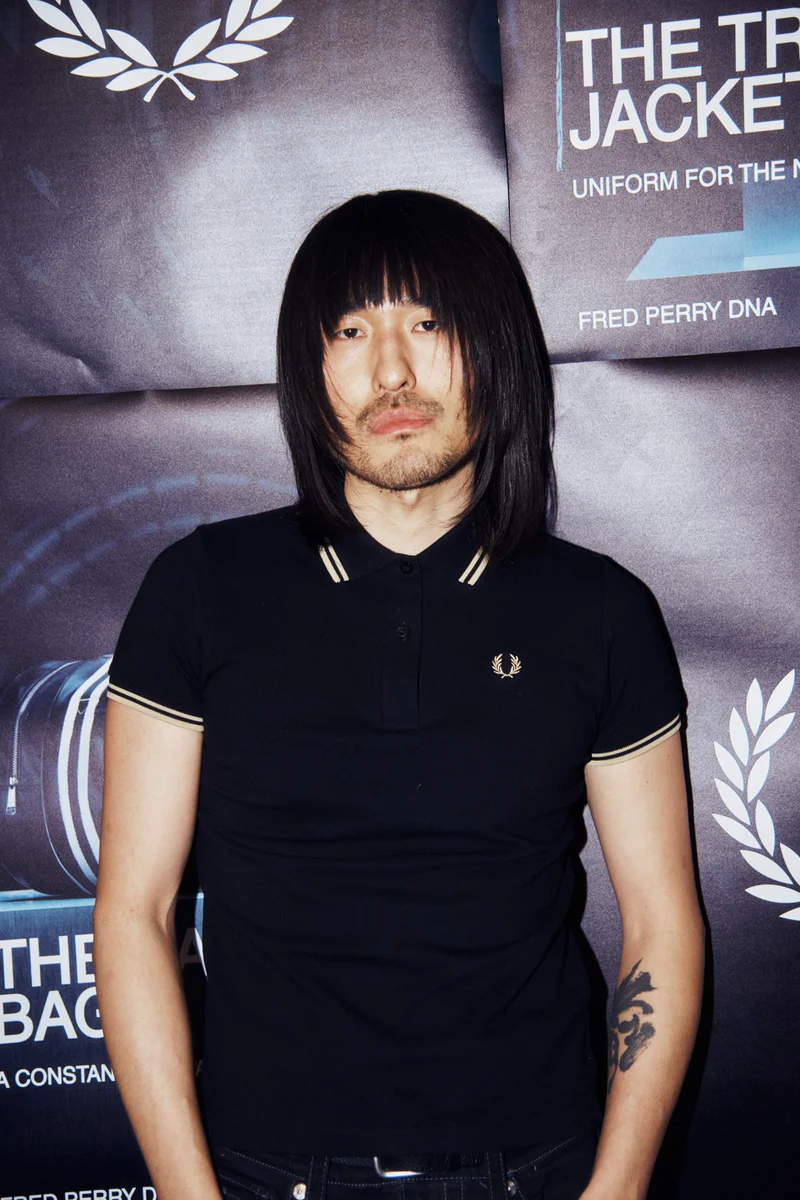 Male model wears an M12 Fred Perry Shirt in Black / Champagne
