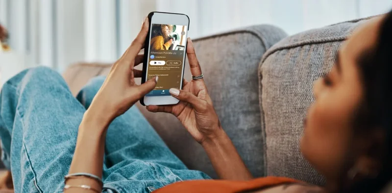 Women lying down listening to Calm on her phone