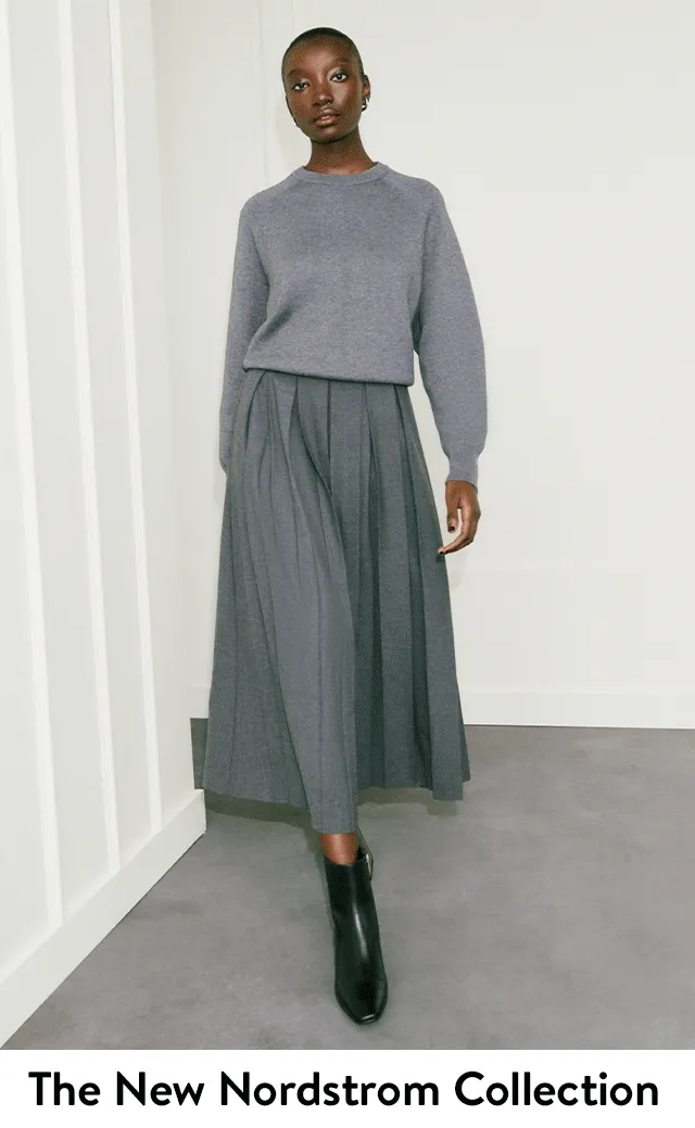A woman wearing a brown blazer and matching trousers. A woman wearing a grey sweater with a grey midi skirt.