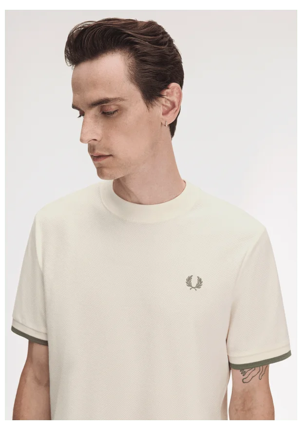 Fred Perry New Releases: Model wears a Fred Perry Tipped Light EcruCuff Piqué Shirt in