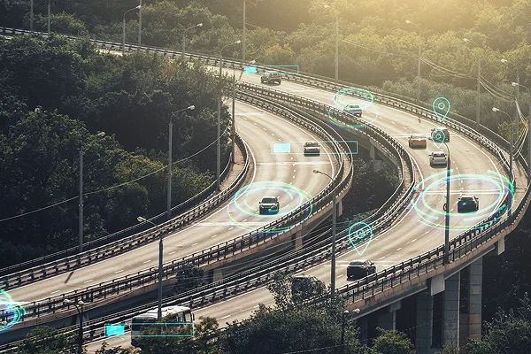 A busy highway overpass with electronic graphics surrounding each vehicle to illustrate intelligent driving technology.