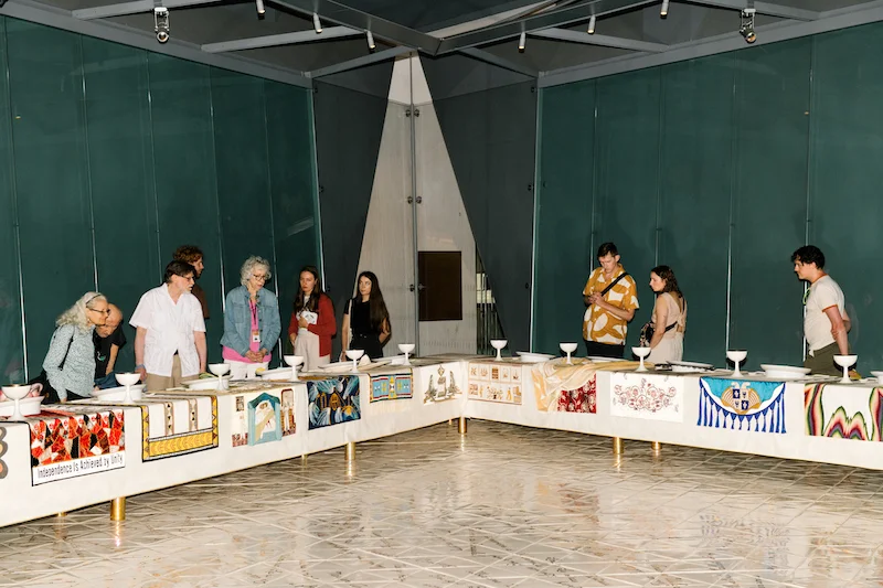 People looking at "The Dinner Party" by Judy Chicago