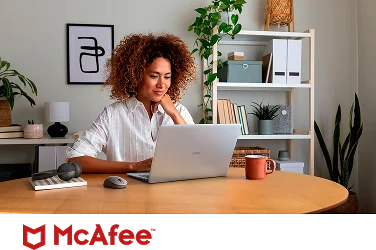 A confident remote worker reviewing their project on a Dell laptop computer above a McAfee logo.