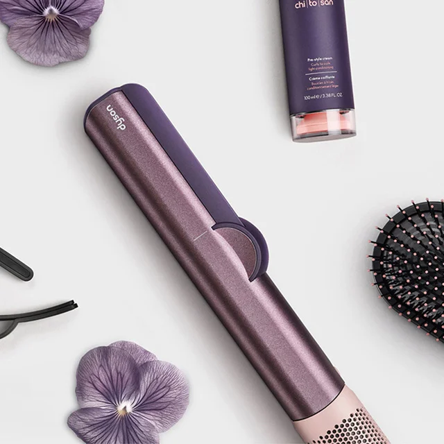 The Dyson Airstrait straightener surrounded by attachments and accessories