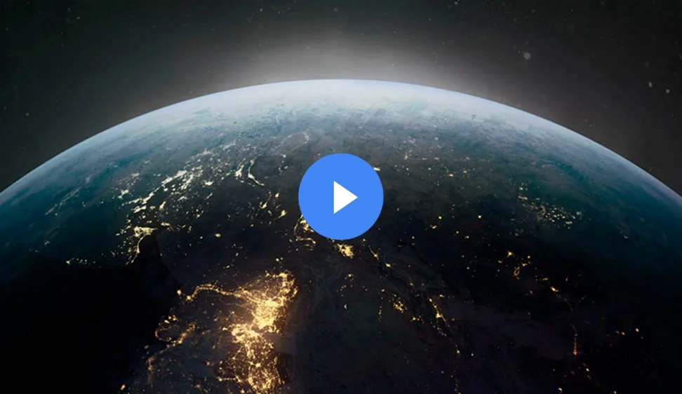 A photograph of roughly the top third of the globe taken from space. Various spots on the globe are lit up, indicating electricity use in highly populated areas.