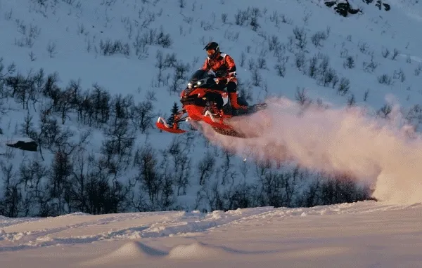Lynx sled jumping over snow bank