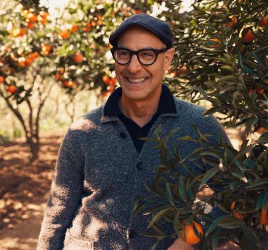 Stanley Tucci stands in a blood orange orchard in Sicily for the National Geographic series Tucci in Italy.