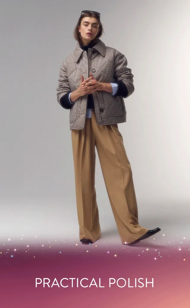 A woman wearing a check-print coat with a sweater and tan trousers.