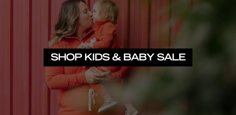 mum and child wearing matching red rompers and text SHOP KIDS & BABY SALE