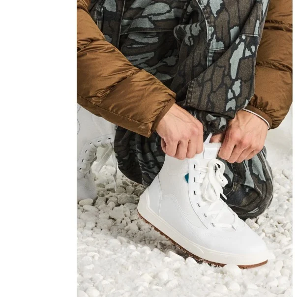 Picture of a male model putting on the brand new Alta High Top.