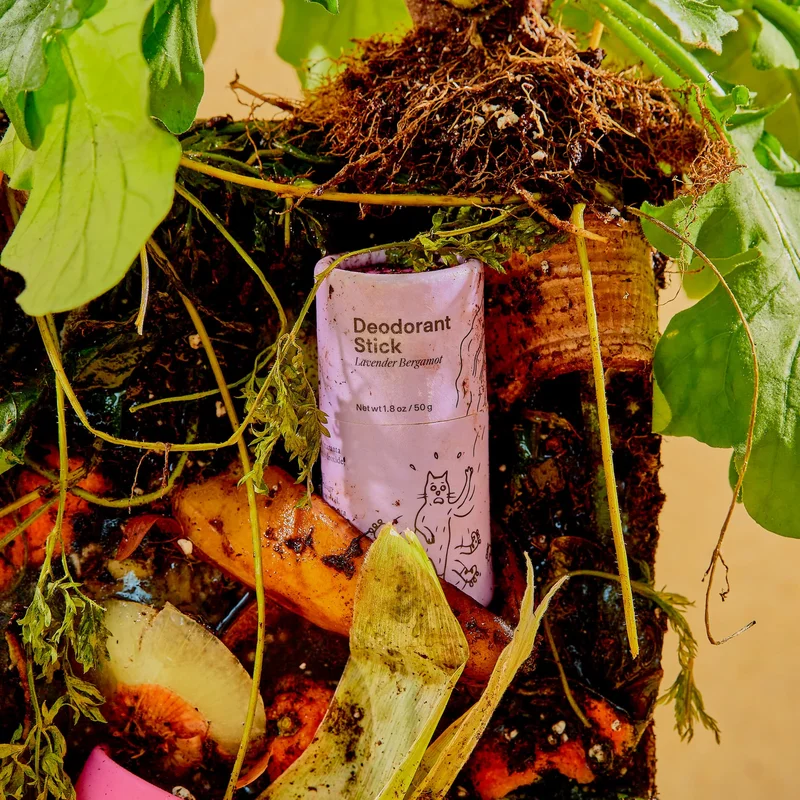 A purple tube of deodorant is stuck in a block of compost