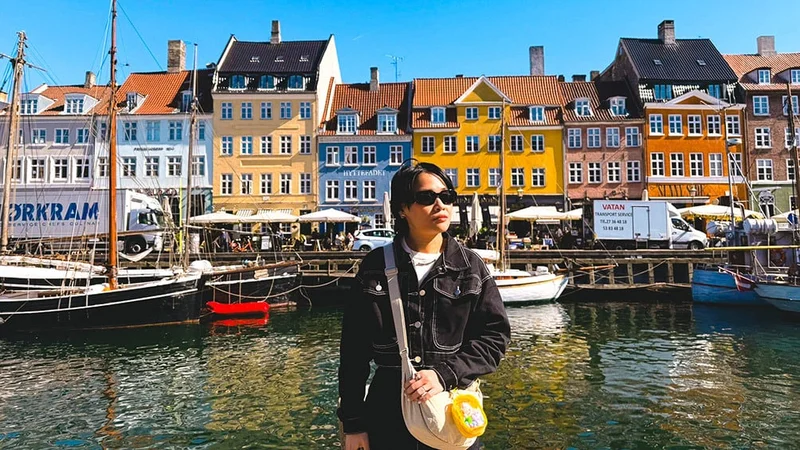 Image description: Tourist walking through Nyhavn, Copenhagen.
