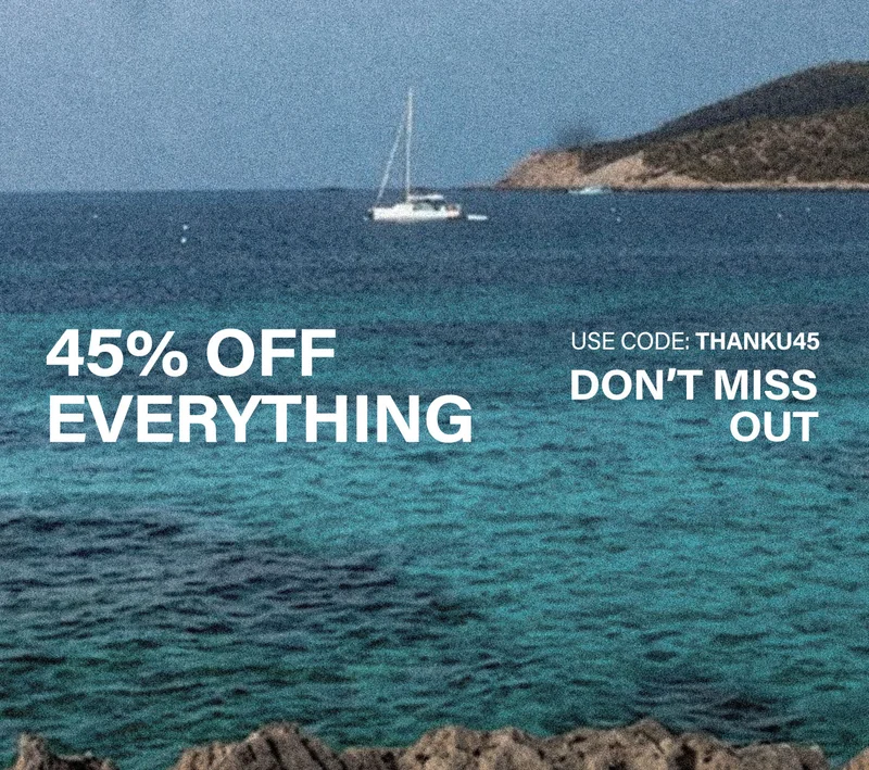 Serene blue-green ocean, white sailboat, and distant island. Promoting a 45% off everything sale. Use code discount code for your discount.