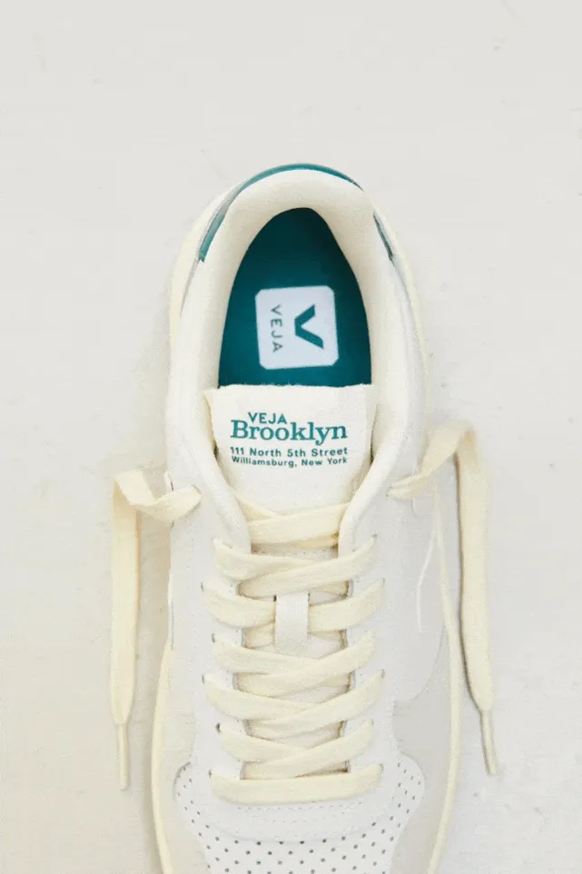 White sneakers that say “Brooklyn” in green on the heel