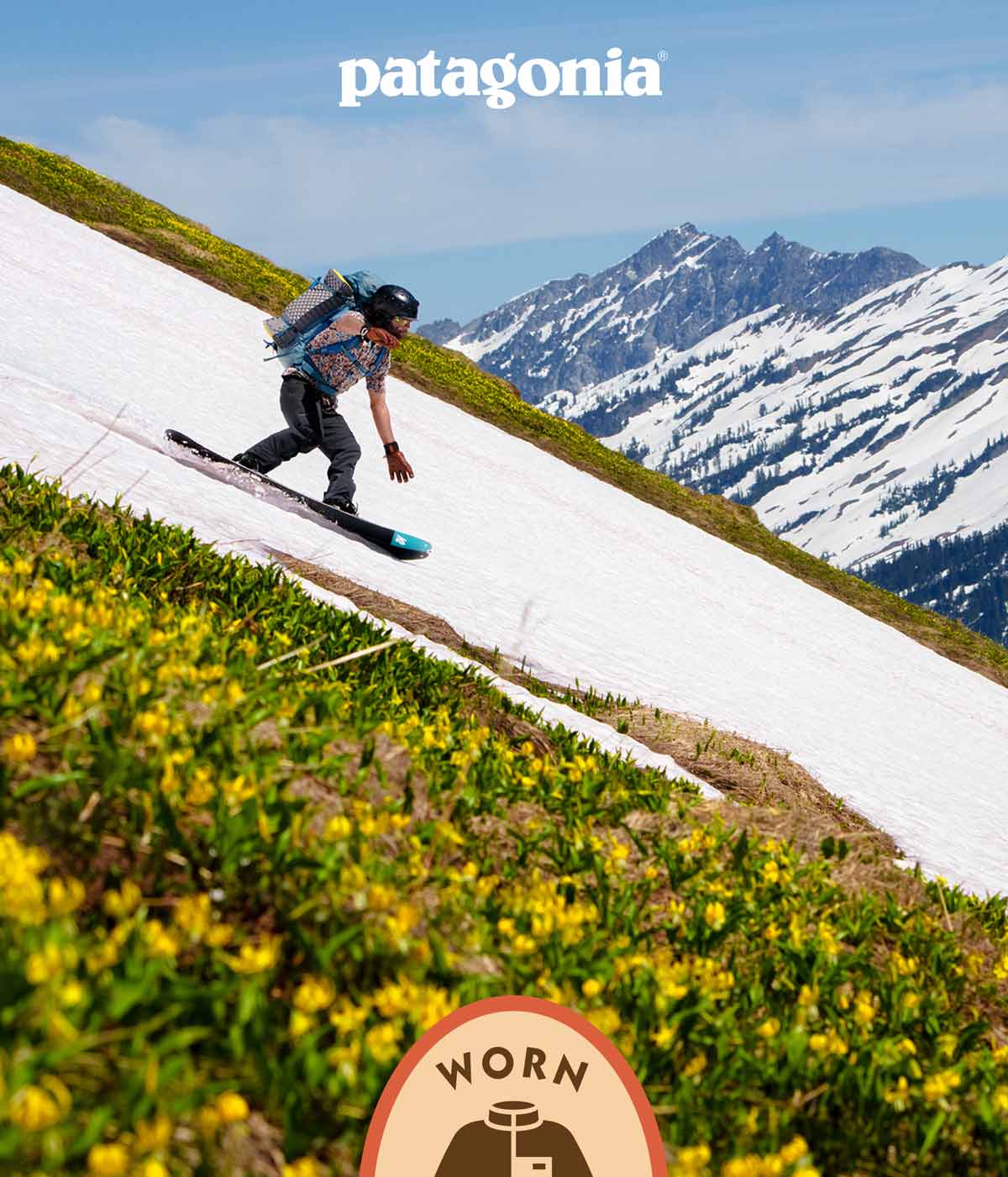 Patagonia Worn Wear. A person snowboarding on a patch of snow running through flowers.