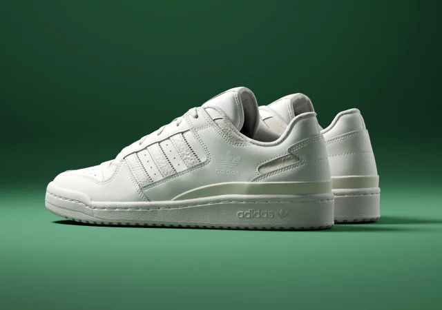 White Forum sneakers in front of a green background