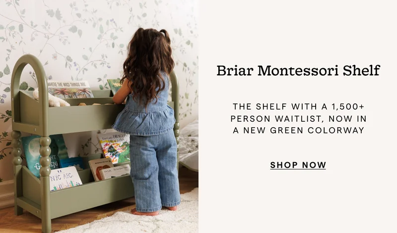 an image of a little girl standing in front of a book shelf