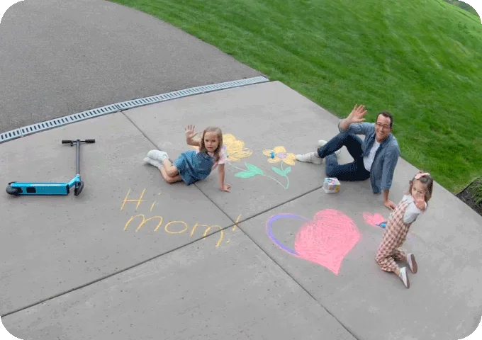 Point of view image from an Arlo Wired Floodlight of a family in a driveway.