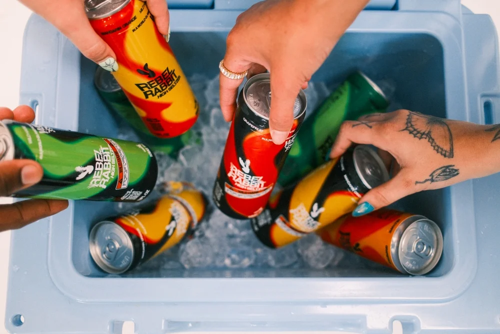 Group of people grabbing a Rebel Rabbit from the cooler.