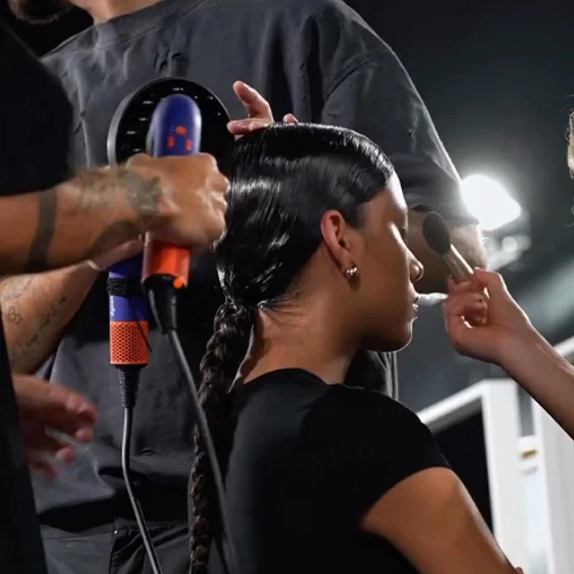 The Dyson Supersonic r hair dryer is used by a team of stylists to style a model’s hair at a fashion event