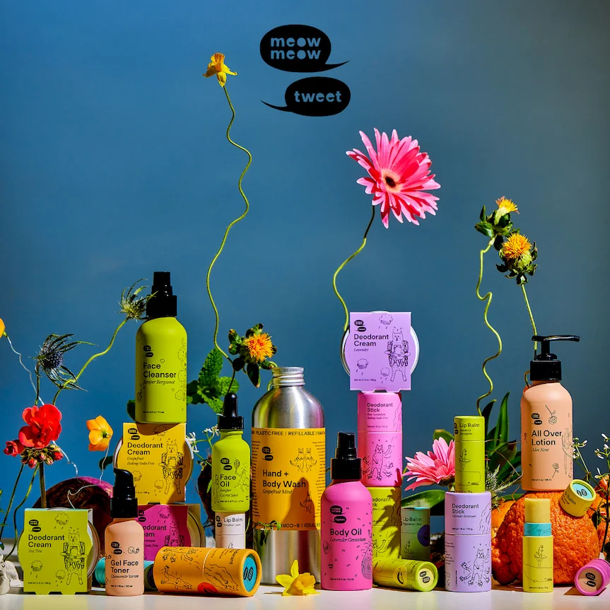 A rainbow of products and flowers are all stacked together on a flat surface, like a messy rainbow