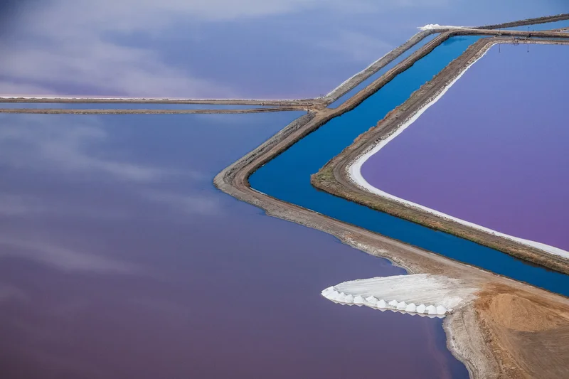 These unmanipulated images from Kost’s window seat help change perspectives and encourage travelers to leave the shades open. In this photo, microorganisms brighten up the San Francisco Bay salt ponds with vibrant colors.