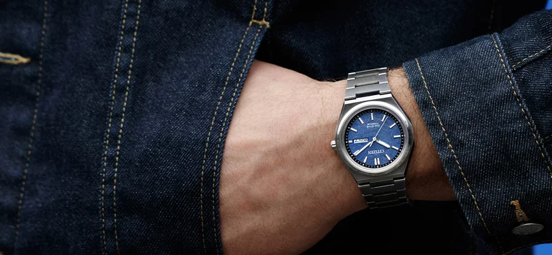 The sporty Zenshin features a silver-tone Super Titanium™ case and matching bracelet. A textured blue dial is accented with an outer minute ring in black and silver-tone markers.