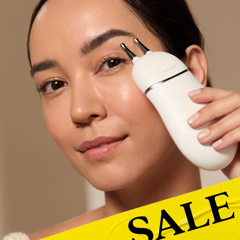 Beautiful woman holding TRINITY+ with Effective Lip & Eye Attachment by brow to open up look of eyes