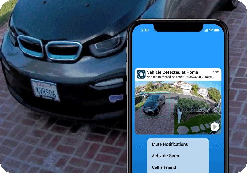 A phone showing a simulated screen image of an Arlo Secure notification. The background shows a simulation of a zoomed image to identify a license plate on a vehicle.