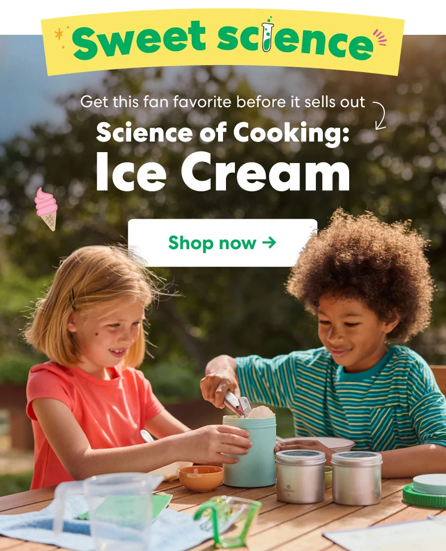 Two kids excitedly make ice cream outdoors using KiwiCo’s Science of Cooking: Ice Cream kit, featuring metal containers and ingredients.