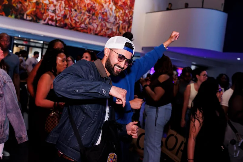 A person smiling and dancing in a crowd