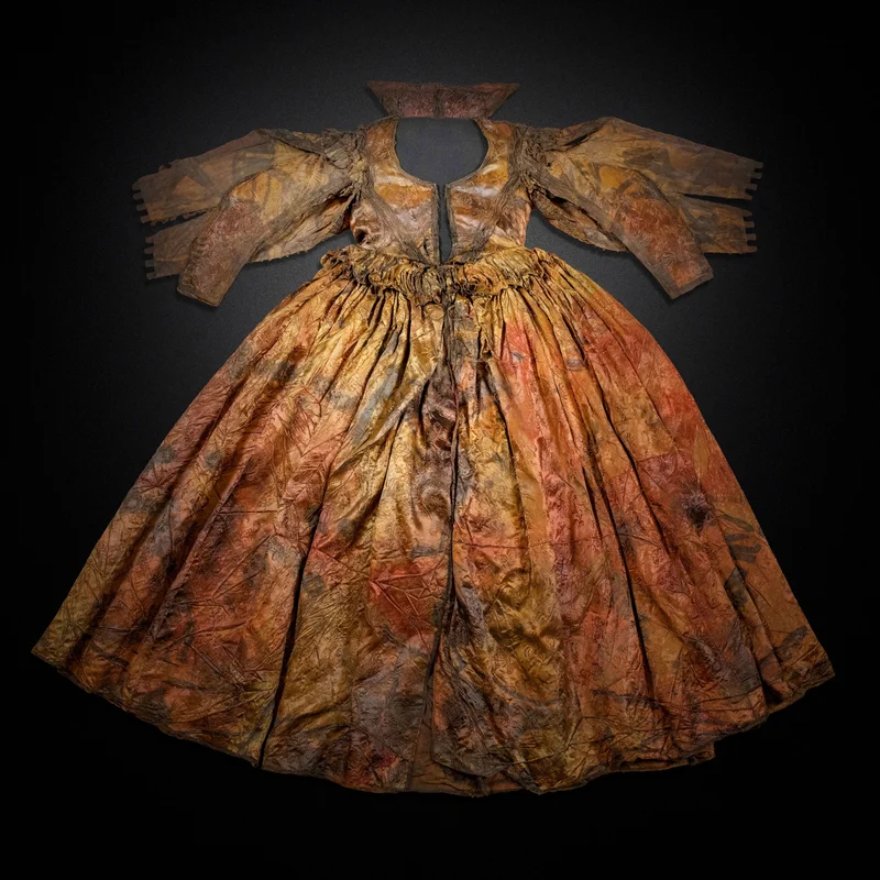A silk damask gown from the Palmwood Wreck is laid flat. The dress is believed to date to around the 1620s.