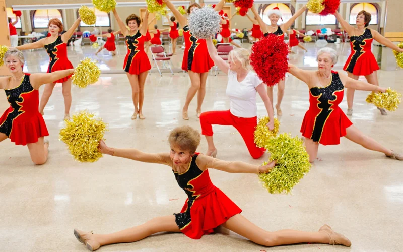A group of elderly women at cheerleading practice.