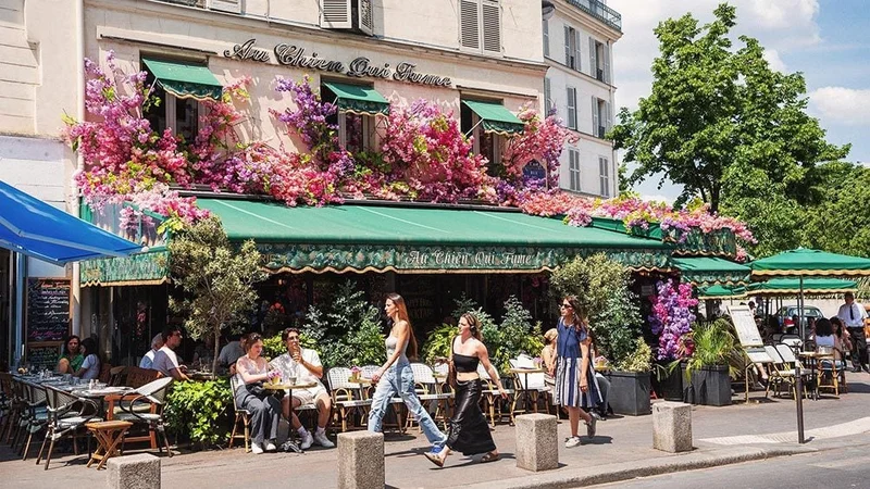 Image description: People walking past cafe in Paris full of flowers.