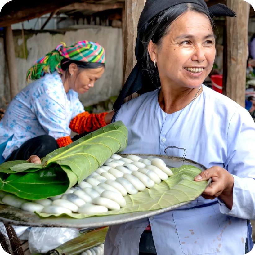 A woman holding fresh food under a leaf.