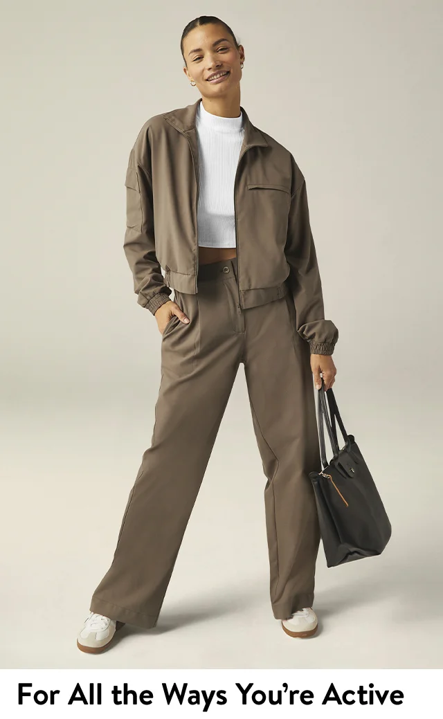 A woman wearing a brown athletic jacket with matching pants and a white top.