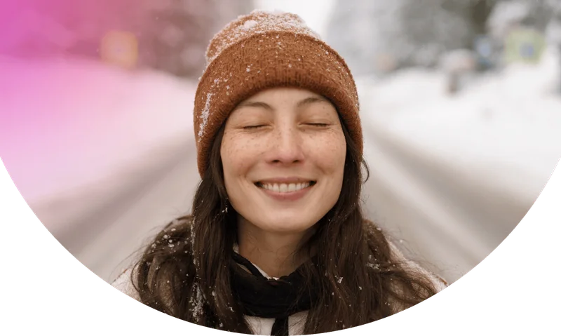 Joyful asian woman in warm hat and trendy coat enjoy frost and snow