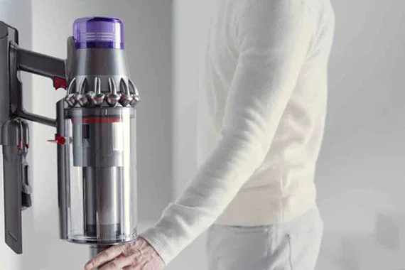 Person placing cordless vacuum on wall mount