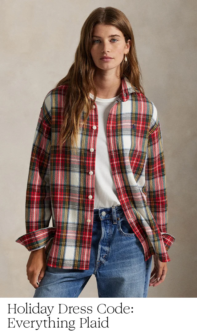 A woman wearing a plaid shirt over a tee with pants.