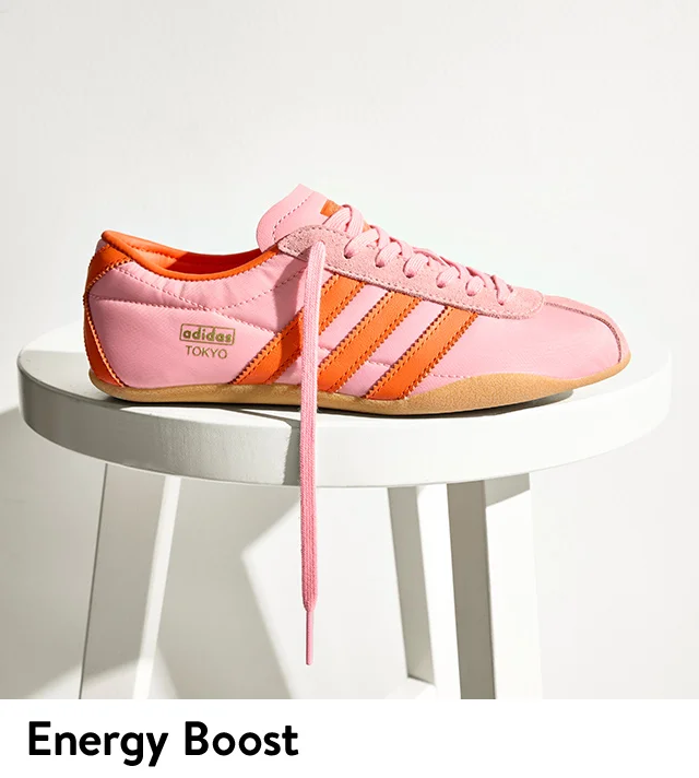 A pink sneaker with orange stripes.