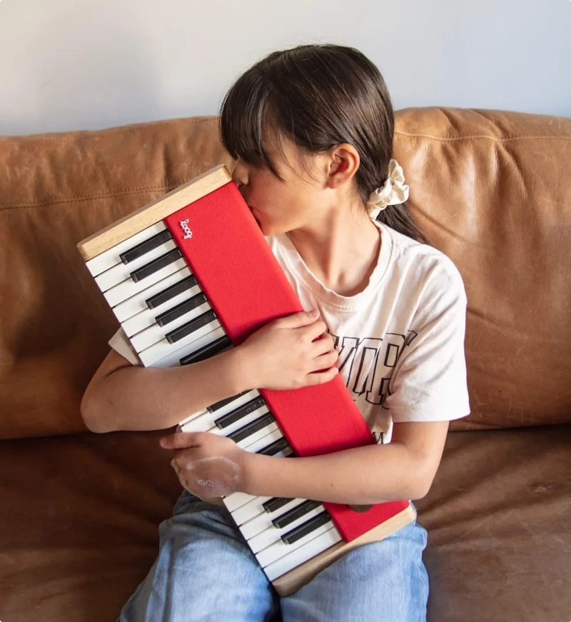 Little girl hugging the piano loog