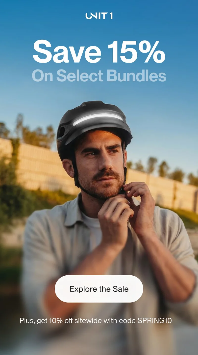 UNIT 1 Spring Sale hero image showing a rider fastening a smart helmet with the message “Save 15% on select bundles,” a call-to-action button, and a note about 10% off sitewide with code SPRING10.